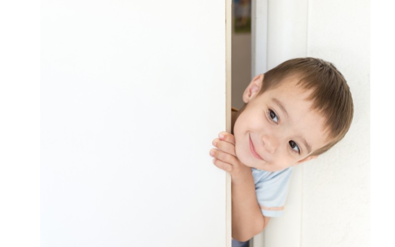 Boy looking from behind a door